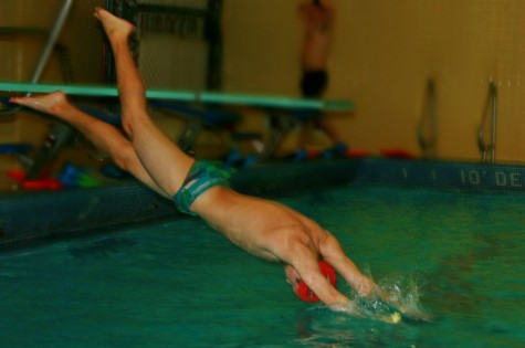 Senior Joe Dever dives into the swimming pool.