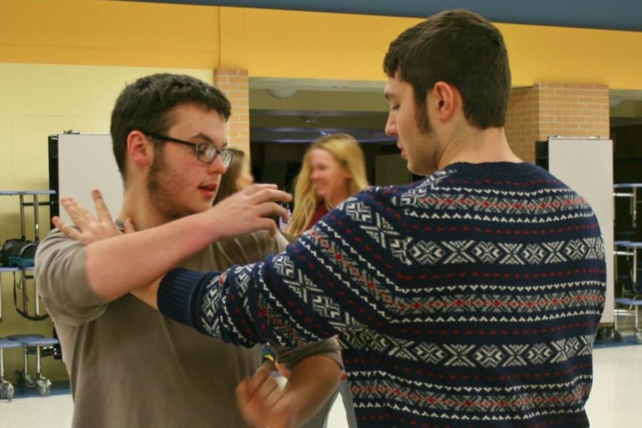Sophomore Anthony Harrison (left) and junior Konstantinos Zaravelis practice a newly-learned self-defense move.
