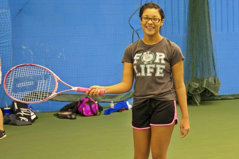 Junior Jasmine Patrick shows off her her tennis racket. 