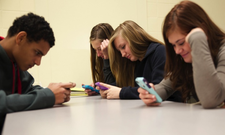 Senior Markeem Davis (left to right) and freshmen Kennedy Lints, Hannah VanOoteghem, and Hannah Alexandar  use their phones at lunch.