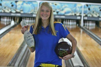 Hannah Ploof holds the bowling pin given to her after shooting her 299-game, as well as the ball that she shot it with. Kearsley beat Linden and Brandon 30-0 in each match.
