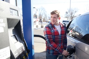 Jacob Murray, senior, pumps gas at the Marathon on Genesee and Richfield, where gas is five cents cheaper if cash is used as payment.  Murray was happy about how slowly the price increased on the pump's display.
