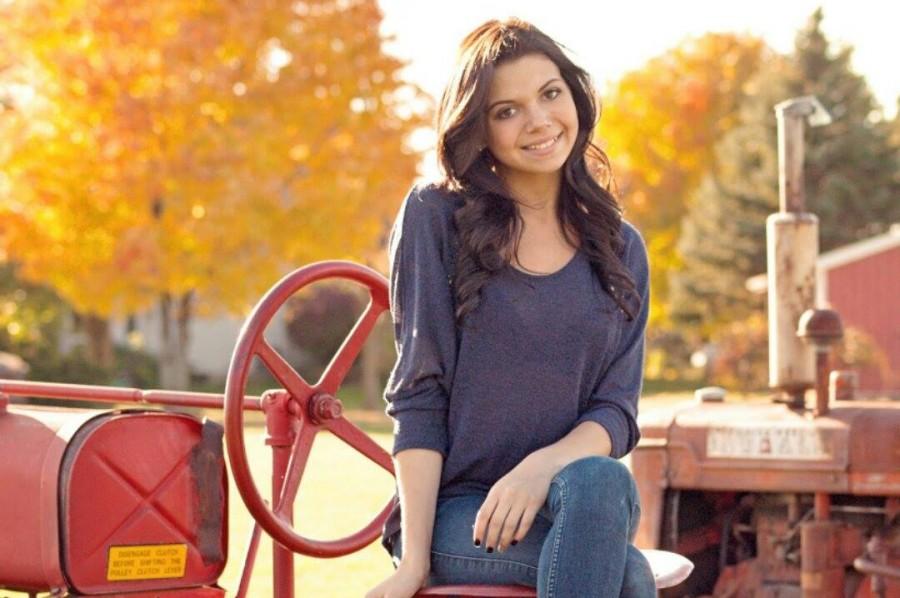 Senior+Abbi+Mezey+sits+on+a+tractor+for+one+of+her+senior+pictures.+