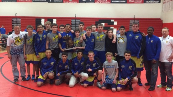 The wrestling team poses with its regional championship trophy on Feb. 18.