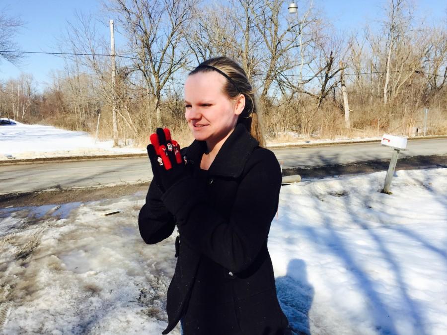 Freshmen Megan Delong rubs her hands together to keep warm while waiting for the bus. 