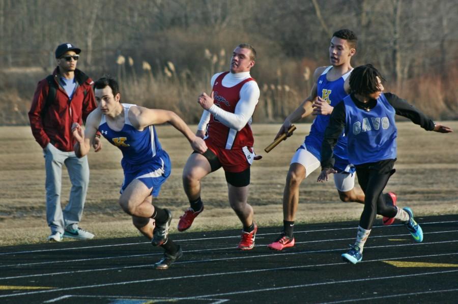 Junior Matt Parkinson (black shoes) accelerates to receive the baton from sophomore Darrion Younger (pink shoes) in the sprint medley relay during the Kearsley Early Bird Relay on April 1. They were both members of the regional championship 800-relay team on May 15 along with juniors Deitrick Young and Jonathan McKay.