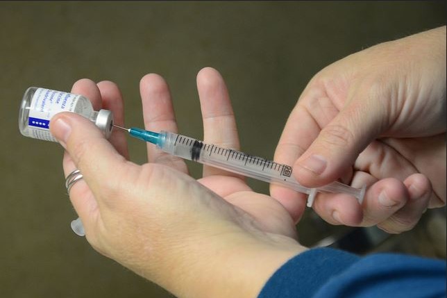 A registered nurse prepares a flu vaccination.