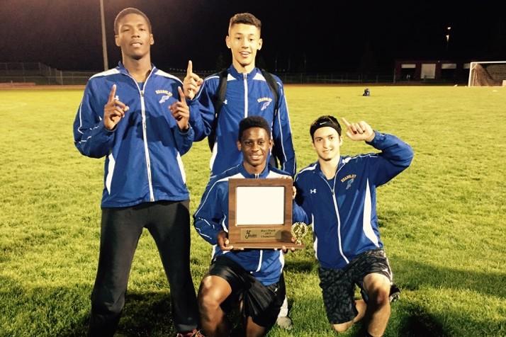 The winning 800-meter relay team of junior Janathon McKay (left back) sophomore Darrion Younger, junior Deitrick Young (bottom left), and junior Matt Parkinson shows off the team's league trophy May 20 at Linden.