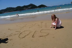 I kneel on the beach in San Sebastian. 