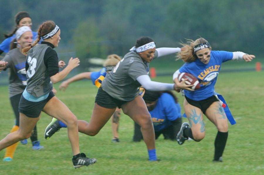 A freshman defender reaches to pull junior Brittney Dick's flag.