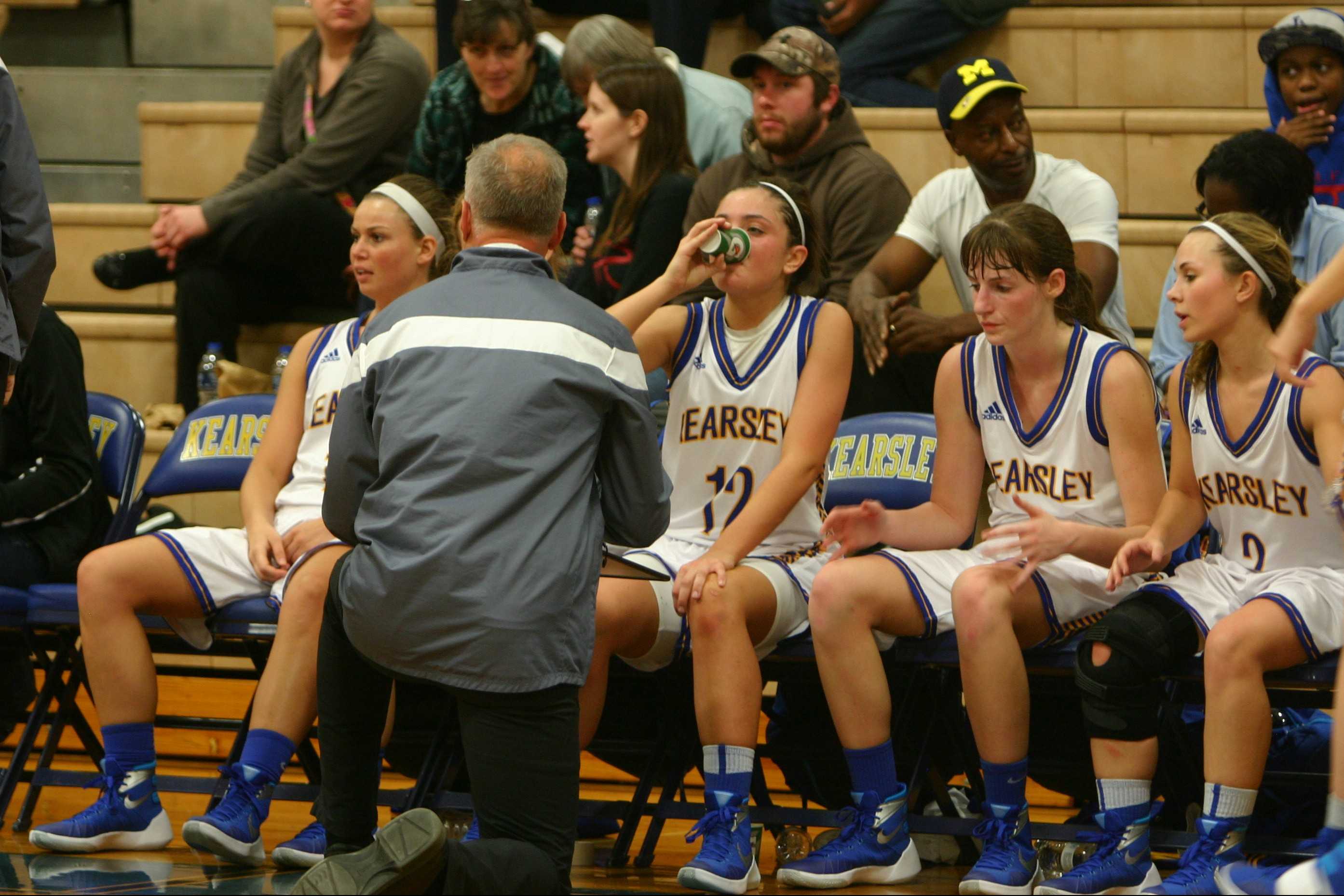 The girls' basketball team listens to directions from Coach Matt Gildner during a timeout. The Hornets lost the game to Swartz Creek on Friday, Dec. 11.