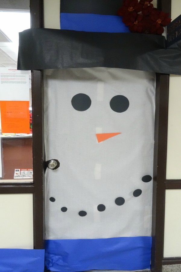 The office staff decorated their door to be a snowman.