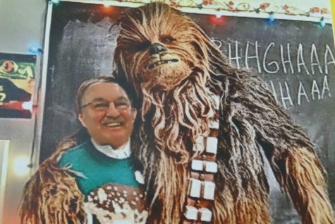 Mr. Boudreau stands in a Christmas sweater with Chewbacca 