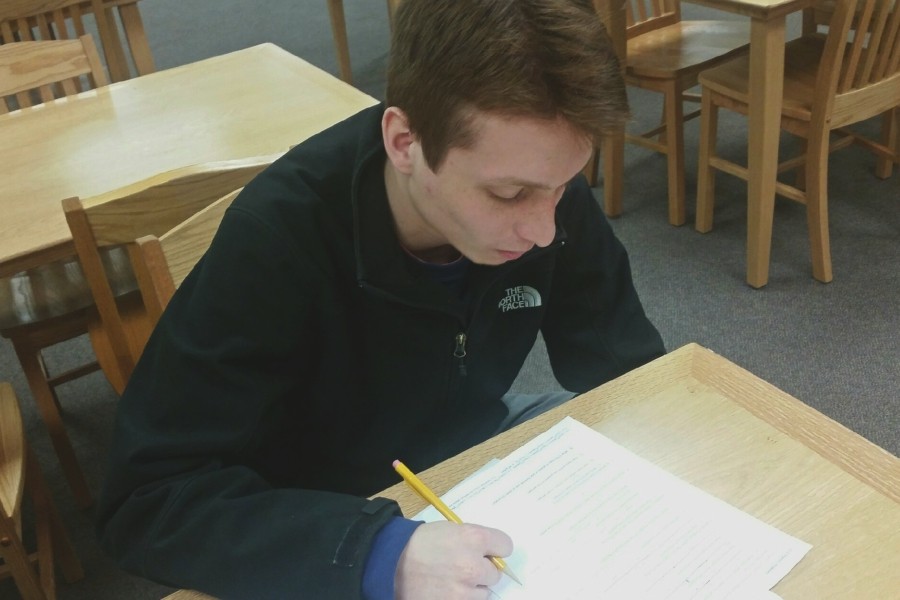 Nick Niles, junior, spends his lunch period working on homework in the media center. 