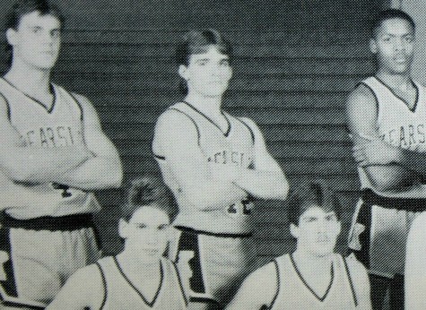 Mr. Mike Simms stands for his basketball team's pictures.