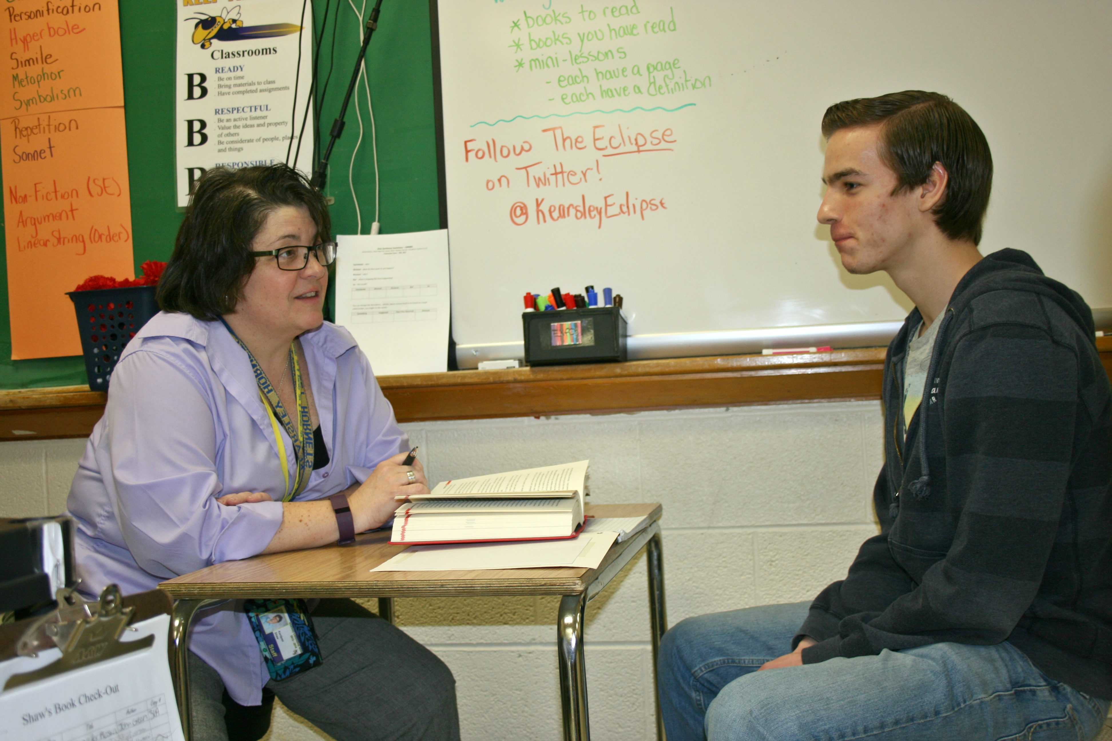 Miss Kari Shaw (left) checks Ben Molter's reading log during a teacher-student conference on Wednesday, March 23.
