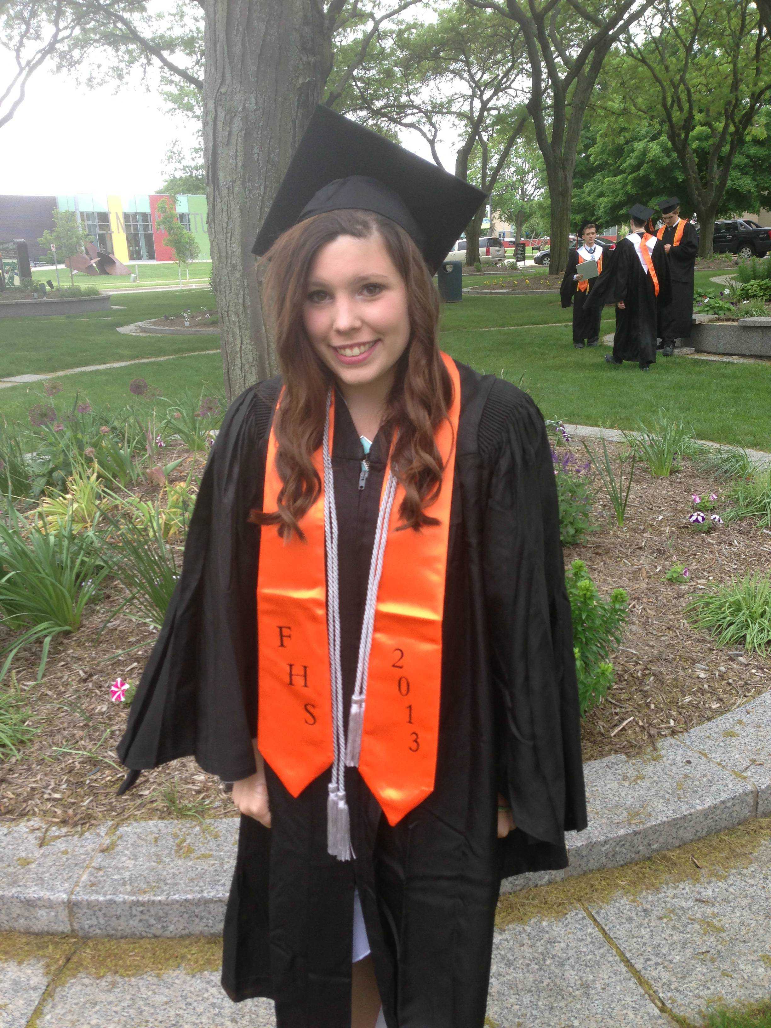 Miss Chelsea Moore smiles while wearing her Flushing High School graduation gown in 2013.