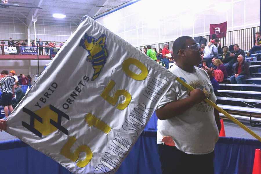 Senior Alex Gatica waves Team 5150's flag to pump up the crowd before a match.