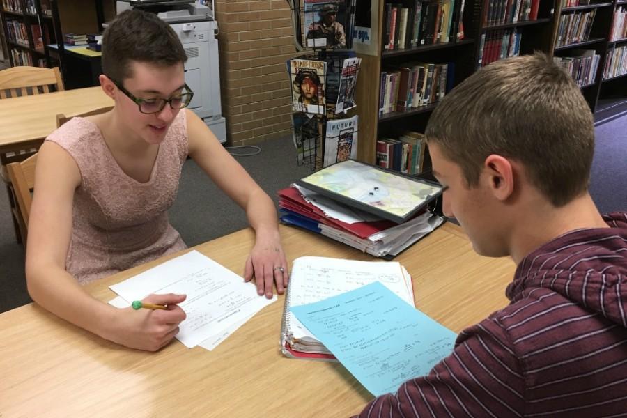 Seniors Taylor Stockton (left) and Aaron Ruhstorfer work on math homework during their lunch period on Tuesday, March 22. Stockton tutors Ruhstorfer for service hours. 