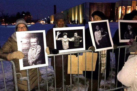 Flint residents hold up photos.