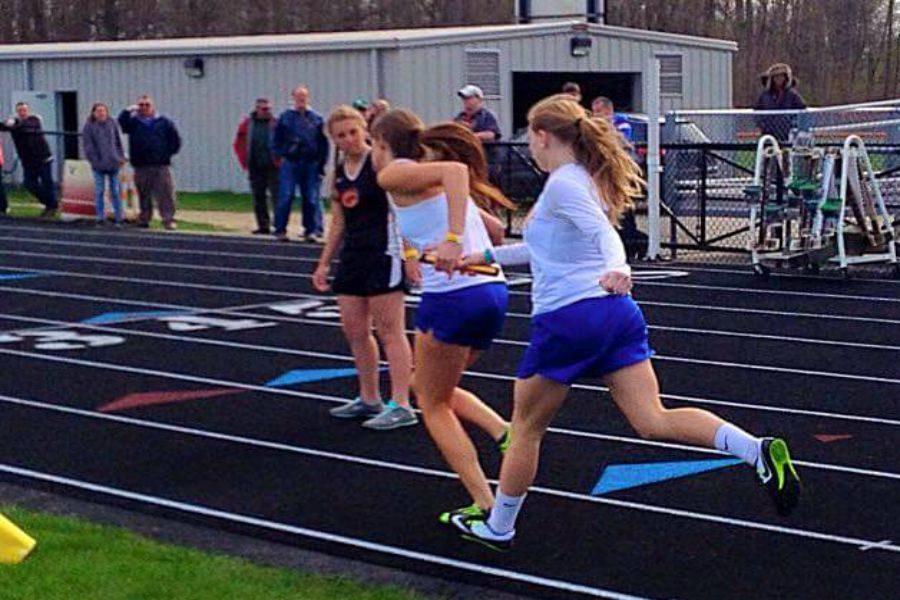 Emalie Lewis, senior, receives a handoff from Madison Jordan, sophomore, in the 800-meter relay.