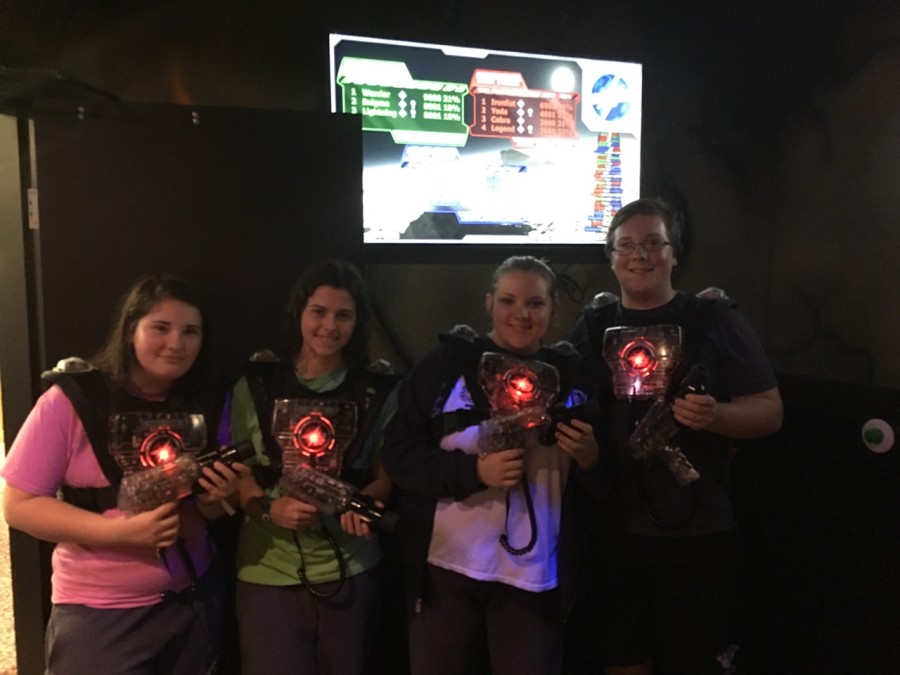 Freshman Allison DePottey (left), Brianna Greer and seniors Makenzie Schroeder and Jacob DePottey pose with their guns during lazer tag. 