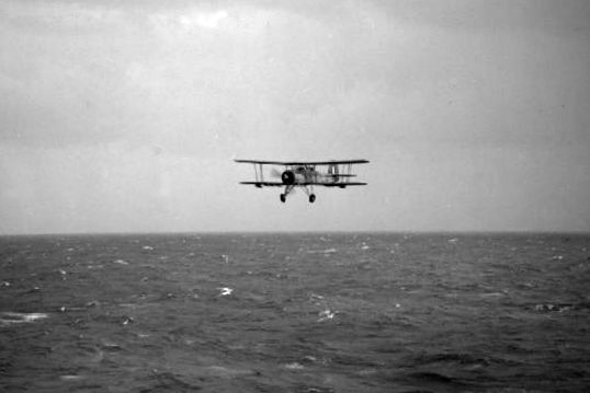 A Fairey Swordfish from the aircraft carrier HMS Ark Royal returns at low level over the sea after making a torpedo attack on the German battleship Bismarck. 