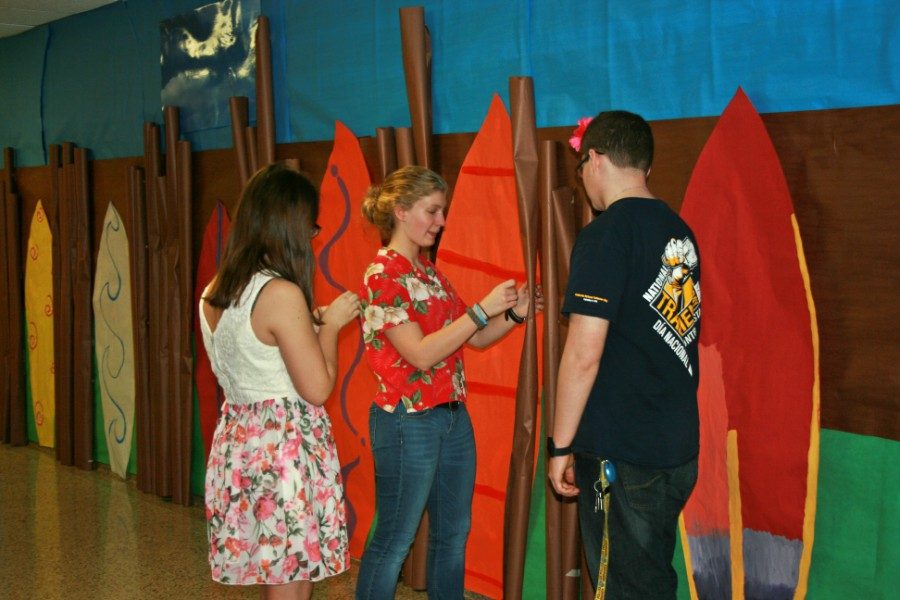 Senior Julie Lemon (center) as well as juniors Rian Schulz (left) and Dylan Phelps help to coordinate other NHS members in decorating a wall. 
