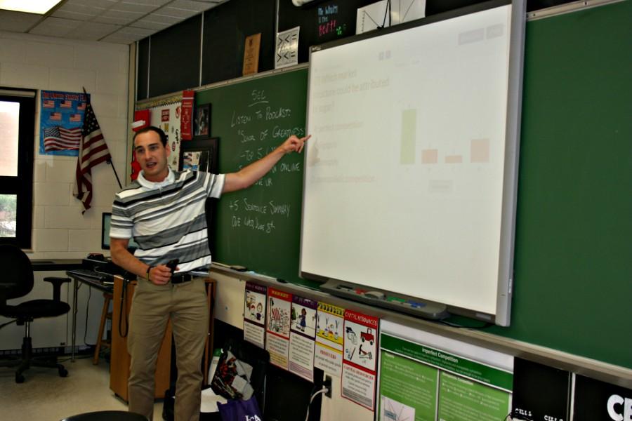 Mr. Michael Whalen, economics teacher, points out students' answers on his SMART board.