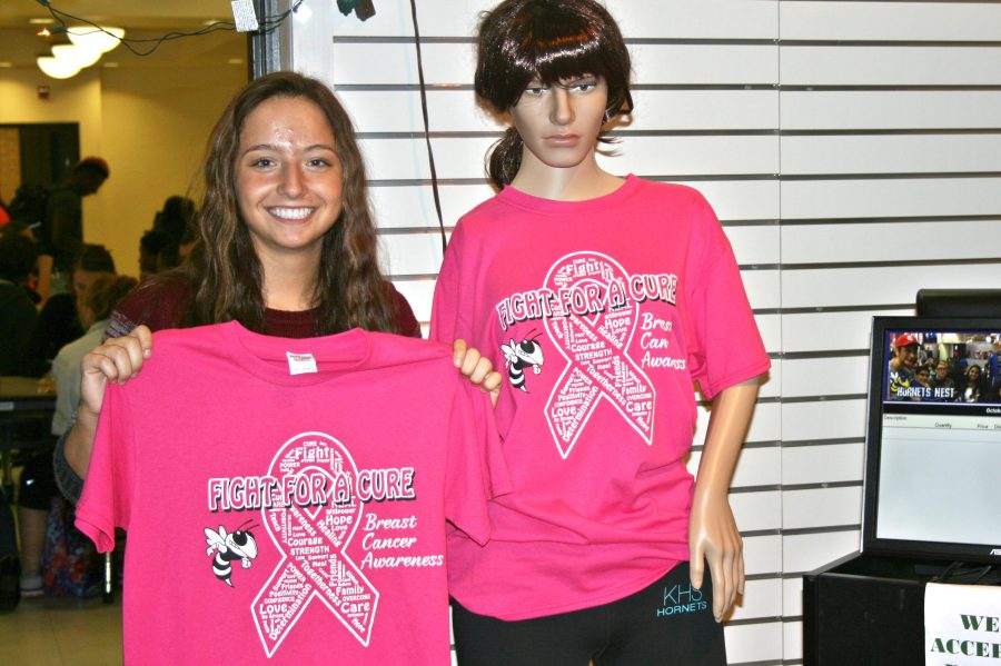 Senior+Chloe+Jankowski+displays+the+Pink+Out+T-shirts+for+the+annual+Pink+Out+football+game+to+bring+awareness+to+breast+cancer.+The+game+is+Friday%2C+Oct.+21%2C+at+Kearsley.