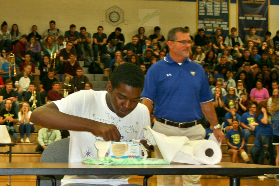 Freshman Johnny Brown shovels ice cream into his mouth as fast as he can during the pep assembly Monday, Oct. 3.