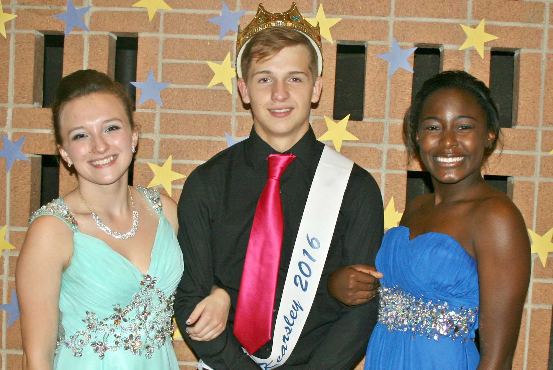 Senior Sadie Saunders (left) and junior Kaylie Hill (right) present Mr. Kearsley 2016, junior Sebastian Young, at the talent show hosted by the cheer team Wednesday, Oct. 12.