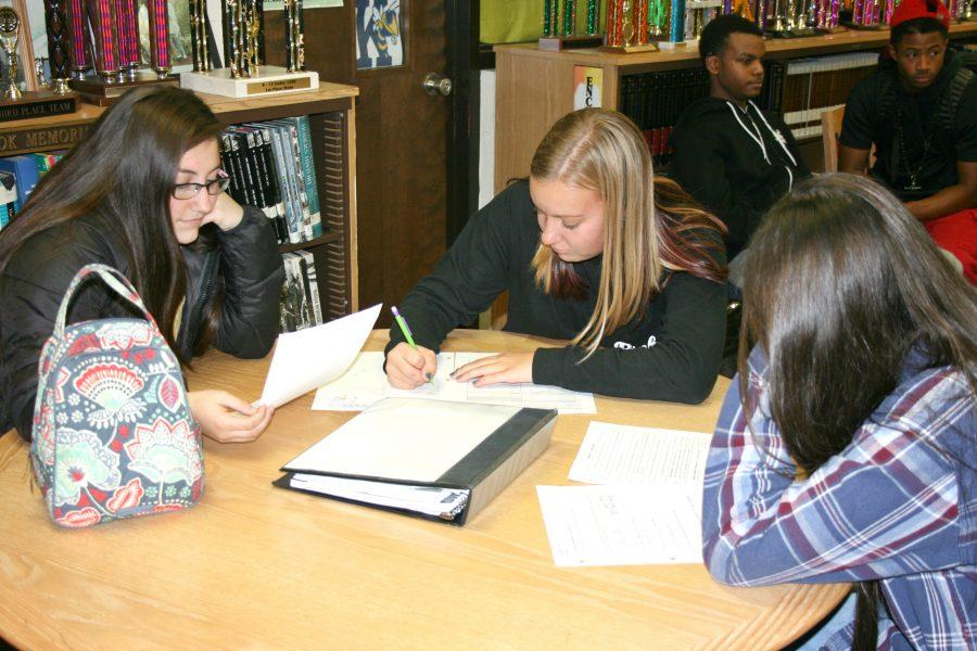 Sophomores Grace Stempie (l to r), Emily Jones, and Ellena Dye study in the library after school on Wednesday, Oct. 26 , while other students talk behind them.
