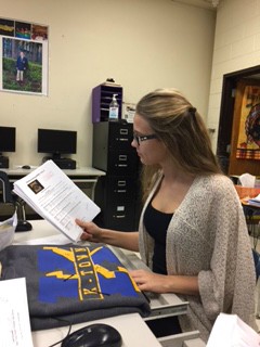 Financial and apparel manger Nickole Sarginson is placing order forms for Kearsley Bowling Spirt Sale and 8th grade volleyball. 