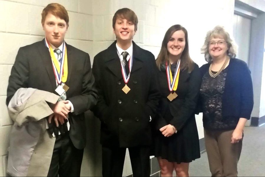 Junior Luke Leblanc (left), senior Nick Niles, and junior Barbara Hawes are all smiles after advancing from the DECA district competition to the state event Tuesday, Dec. 20, at Saginaw Valley State University. Mrs. Kim Guest (right), marketing teacher, is pleased for her students. 