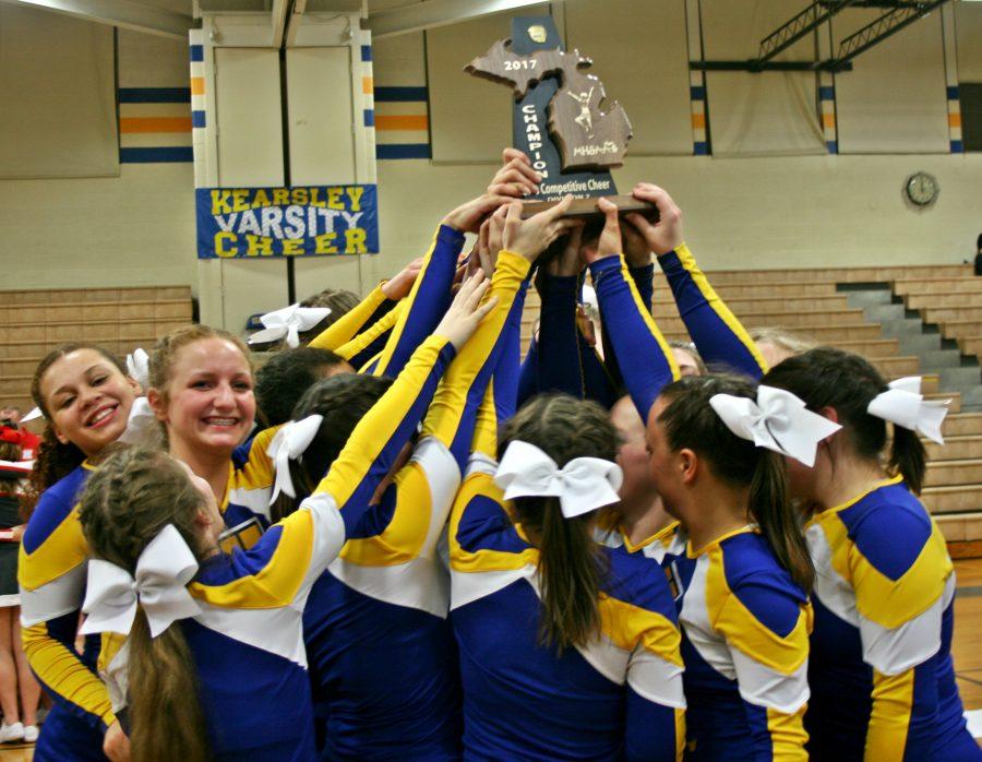 The+cheer+teams+hoists+its+district+championship+trophy+after+claiming+the+title+on+Friday%2C+Feb.+17%2C+at+home.