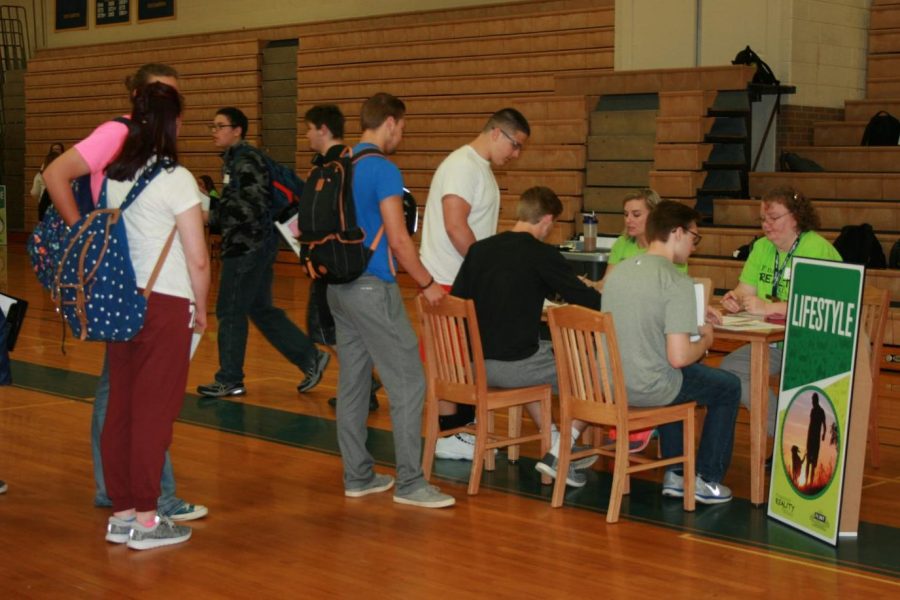 Juniors wait in line at the lifestyle station of the financial fair at Kearsley on Thursday, April 27. At this station, students looked at costs associated with leisure activities.