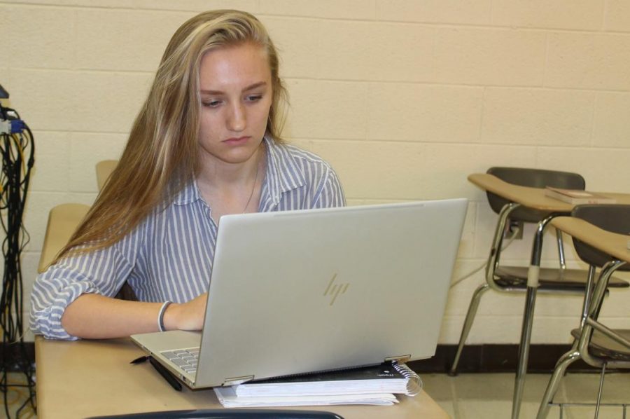 Senior Hannah VanOoteghem works on her laptop computer. The first time she used the computer, a hacker infiltrated it.
