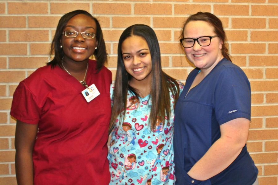 Seniors Kenisha Finley (l to r), Jennifer Fraley, and Olivia Dunsmore work at a nursing home as part of their nursing class at the Genesee Career Institute.