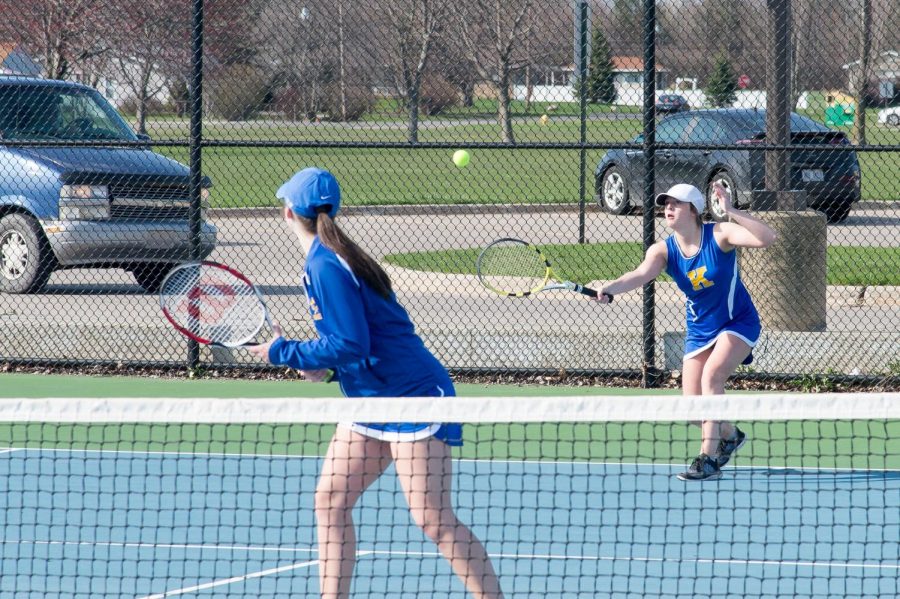 Current senior Mallory Teed prepares to return the ball and junior Ellena Dye watches her teammate in a match from 2017.