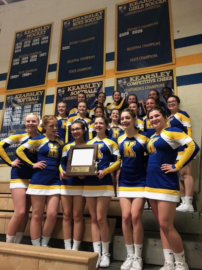 The cheer team stands proudly with its trophy and newly added league champion banner. 