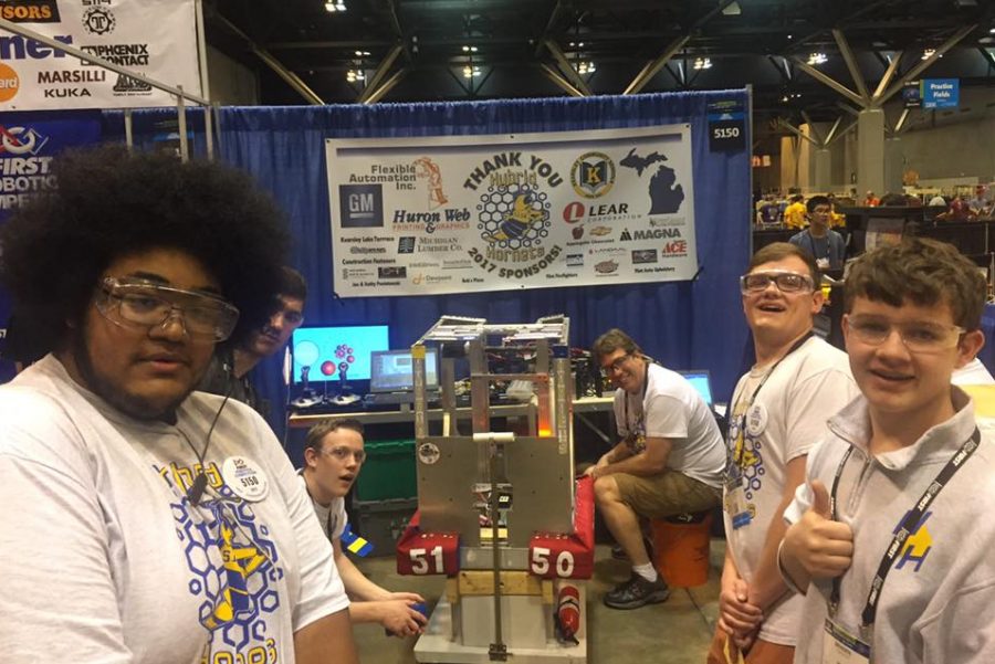 Members of the Hybrid Hornets robotics team pose with their robot at the St. Louis world competition in 2017
