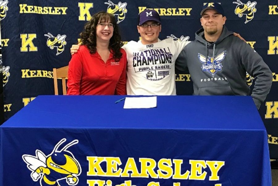 Senior Bailey Douglas  smiles with his father, Mr. Todd Douglas and his stepmother Mrs. Lisa Douglas, as he signs a National Letter of Intent on Feb. 7 to play football at the University of Mount Union.