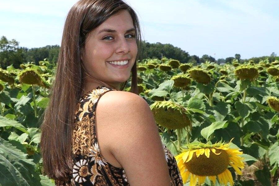 Senior+Rachel+Miller+smiles+in+a+field+of+sunflowers.