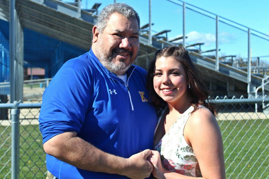 Mr. Fernando Mia (left) and senior Hailey Anderson take prom pictures together at the football field.
