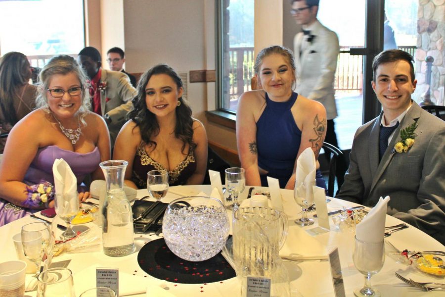Senior Karinna Glandon (l to r), senior Karlee Griffin, junior Madison Kreinbrink, and senior Riccardo Di Giovanni sit together during prom night.