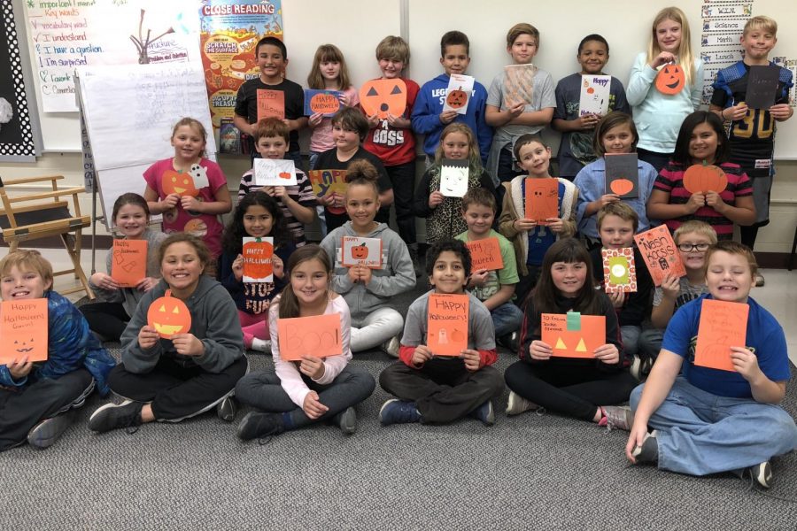 Fiedler students in Mrs. Rae Puffers class smile with the cards from Ms. Diane Hunts psychology classes.