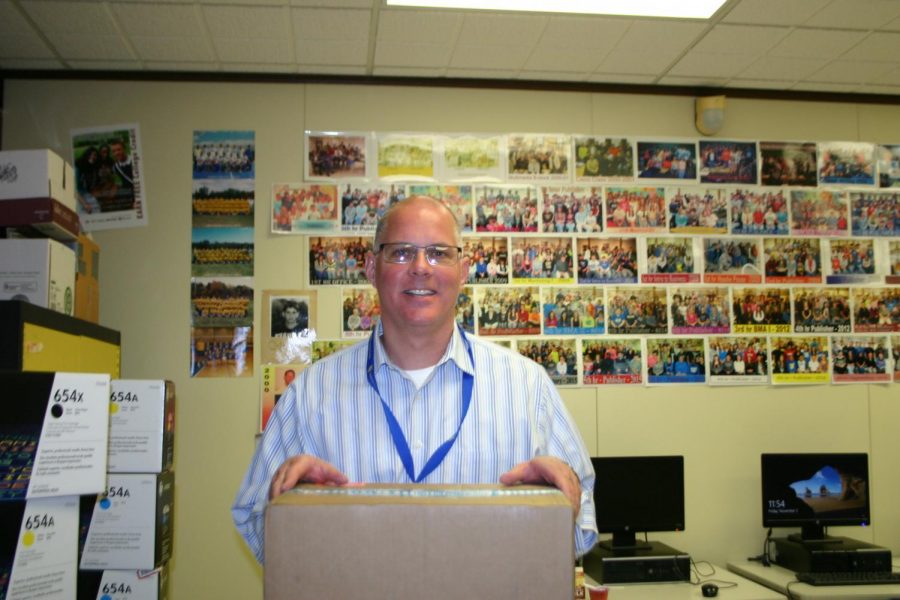 Mr. Brian Clark posing with a box of printer ink. 