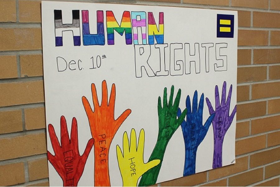 A Gay-Straight Alliance poster promotes equality on Human Rights Day with multicolored hands with words like equality and hope on them.