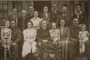Ms. Anneke Burke-Kooistra poses with her family and the eight Jewish refugees they hid on May 5, 1945, after World War II ended.